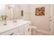 Well-lit bathroom featuring a vanity, toilet, and decorative floral artwork, enhancing the room's aesthetic appeal at 405 Bramble Ln, Clayton, NC 27527