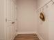 Hallway with stylish wood floors, white wainscoting and convenient hooks for coats and accessories at 405 Bramble Ln, Clayton, NC 27527