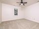 Comfortable bedroom features neutral carpet, a ceiling fan, and a large window at 4416 Lancashire Dr, Raleigh, NC 27613