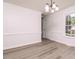 Bright dining room with hardwood floors, crown molding, and a modern chandelier at 4416 Lancashire Dr, Raleigh, NC 27613