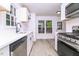 Kitchen boasts white cabinets, stainless steel appliances, hardwood floors, and natural light at 4416 Lancashire Dr, Raleigh, NC 27613