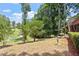 Landscaped backyard with lush greenery, mature trees, and partial view of wooden deck at 4733 Royal Troon Dr, Raleigh, NC 27604