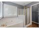 Bathroom featuring a tub with gold fixtures and a glass-enclosed shower at 4733 Royal Troon Dr, Raleigh, NC 27604