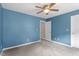 Bedroom with carpet, ceiling fan and two windows and entrance to another room at 4733 Royal Troon Dr, Raleigh, NC 27604