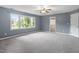 Spacious bedroom with large windows, a ceiling fan, and neutral carpeting at 4733 Royal Troon Dr, Raleigh, NC 27604