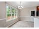 Bright breakfast nook featuring a chandelier and large windows overlooking a wooded area at 4733 Royal Troon Dr, Raleigh, NC 27604
