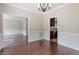 Open-concept dining area featuring hardwood floors, white wainscoting, and views into the kitchen at 4733 Royal Troon Dr, Raleigh, NC 27604