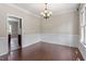 Formal dining room featuring beautiful wainscoting, modern chandelier, and hardwood floors at 4733 Royal Troon Dr, Raleigh, NC 27604