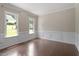 Bright living space featuring hardwood floors, wainscoting, and multiple windows for ample natural light at 4733 Royal Troon Dr, Raleigh, NC 27604