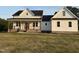 Charming white farmhouse-style home featuring a welcoming front porch with stylish black railings and brick accents at 50 Leah Ln, Louisburg, NC 27549