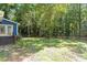 Beautiful backyard with a well-maintained lawn, mature trees, and a classic wooden fence at 5124 Lazywood Ln, Durham, NC 27712