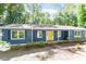 Charming blue home with a bright yellow front door and meticulously kept landscaping at 5124 Lazywood Ln, Durham, NC 27712