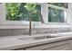 Close-up of stainless steel kitchen sink with gooseneck faucet and tiled backsplash under window at 5124 Lazywood Ln, Durham, NC 27712
