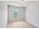 Cozy bedroom with plush carpet, natural light from a window, and neutral color scheme at 529 Forestville Rd, Wake Forest, NC 27587