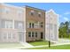Brick townhome features a manicured lawn, neutral paint and charming black trimmed windows and doors at 529 Forestville Rd, Wake Forest, NC 27587