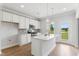 Bright kitchen featuring white cabinets, a stainless steel range, and a center island with pendant lighting at 529 Forestville Rd, Wake Forest, NC 27587