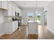 Modern white kitchen with stainless steel appliances, center island, and a door to the outside at 529 Forestville Rd, Wake Forest, NC 27587