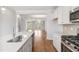 Modern kitchen features white cabinets, stainless appliances, and opens into a living area with a view of a deck at 529 Forestville Rd, Wake Forest, NC 27587