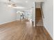Open-concept living area with hardwood floors, a ceiling fan, and stairs leading to the upper level at 529 Forestville Rd, Wake Forest, NC 27587