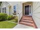 Welcoming front entry featuring classic brick steps, a dark wood door, and beautifully landscaped surroundings at 6205 Houndsman Ct, Raleigh, NC 27616