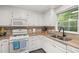 Bright kitchen featuring white cabinets, tile backsplash, and view of the backyard at 6205 Houndsman Ct, Raleigh, NC 27616