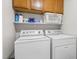 Laundry area features upper cabinets and shelving above the washer and dryer at 6205 Houndsman Ct, Raleigh, NC 27616