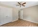 Bedroom with ceiling fan and closet featuring wood-look flooring and neutral paint at 7082 Cornwall Rd, Oxford, NC 27565