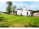 Expansive backyard featuring lush green grass and white home exterior at 7304 Wexford Woods Ln, Wake Forest, NC 27587