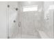 Modern shower with glass door, window, and tiled walls with built in seat at 7304 Wexford Woods Ln, Wake Forest, NC 27587