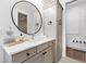 Bathroom featuring a decorative mirror, updated lighting and sink with stone countertops at 7304 Wexford Woods Ln, Wake Forest, NC 27587