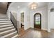 Grand entryway with hardwood floors, stairs and a dark wood door with a glimpse of the bedroom at 7304 Wexford Woods Ln, Wake Forest, NC 27587