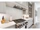 Kitchen featuring a gas range, marble backsplash, quartz countertops, and shaker style cabinets at 7304 Wexford Woods Ln, Wake Forest, NC 27587