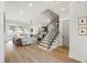 Spacious and well-lit living room with hardwood floors, comfortable seating and view of staircase at 7304 Wexford Woods Ln, Wake Forest, NC 27587