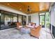 Cozy screened porch with stone floor, wood ceiling and wicker furniture at 7304 Wexford Woods Ln, Wake Forest, NC 27587