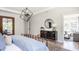 Bright main bedroom featuring modern lighting fixture, decorative mirror, and stylish furnishings at 812 Ballaster Rd, Fuquay Varina, NC 27526