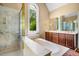 Elegant bathroom with marble shower, soaking tub, and double vanities, creating a spa-like retreat with natural light at 8200 Bromley Rd, Hillsborough, NC 27278