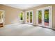 Bright bedroom with multiple French doors, providing views of greenery and access to outdoor spaces at 8200 Bromley Rd, Hillsborough, NC 27278