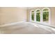Spacious bedroom with neutral carpet and views to lush landscaping from three arched windows at 8200 Bromley Rd, Hillsborough, NC 27278