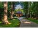 Brick home nestled among mature trees, offering privacy and curb appeal at 8200 Bromley Rd, Hillsborough, NC 27278