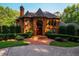 Imposing brick home features a manicured lawn and inviting walkway to the entrance at 8200 Bromley Rd, Hillsborough, NC 27278