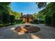 Stately brick home boasts manicured landscaping and circular driveway with fountain at 8200 Bromley Rd, Hillsborough, NC 27278