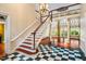 Elegant foyer with a grand staircase, chandelier, and black and white checkered tile flooring at 8200 Bromley Rd, Hillsborough, NC 27278