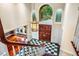 Elegant foyer featuring checkerboard tile, wooden accents, stairs, and a decorative light fixture at 8200 Bromley Rd, Hillsborough, NC 27278