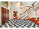 Grand foyer with a black and white checkered floor, staircase, chandelier, and a spacious entrance at 8200 Bromley Rd, Hillsborough, NC 27278
