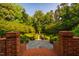 Beautiful symmetrical garden design with a fountain in the center, framed by manicured hedges and lush trees at 8200 Bromley Rd, Hillsborough, NC 27278