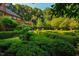 Lush garden view highlighting the home's exterior and meticulously manicured hedges and garden features at 8200 Bromley Rd, Hillsborough, NC 27278