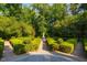Beautiful symmetrical garden design with a fountain in the center, framed by manicured hedges and lush trees at 8200 Bromley Rd, Hillsborough, NC 27278