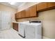 Practical laundry room featuring tiled floors, matching washer and dryer, and updated cabinets at 8200 Bromley Rd, Hillsborough, NC 27278