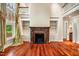 Open-concept living room featuring a fireplace, built-in shelves, hardwood floors, and natural light from large windows at 8200 Bromley Rd, Hillsborough, NC 27278