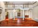 Open concept living room with a soaring ceiling, hardwood floors, and decorative columns at 8200 Bromley Rd, Hillsborough, NC 27278